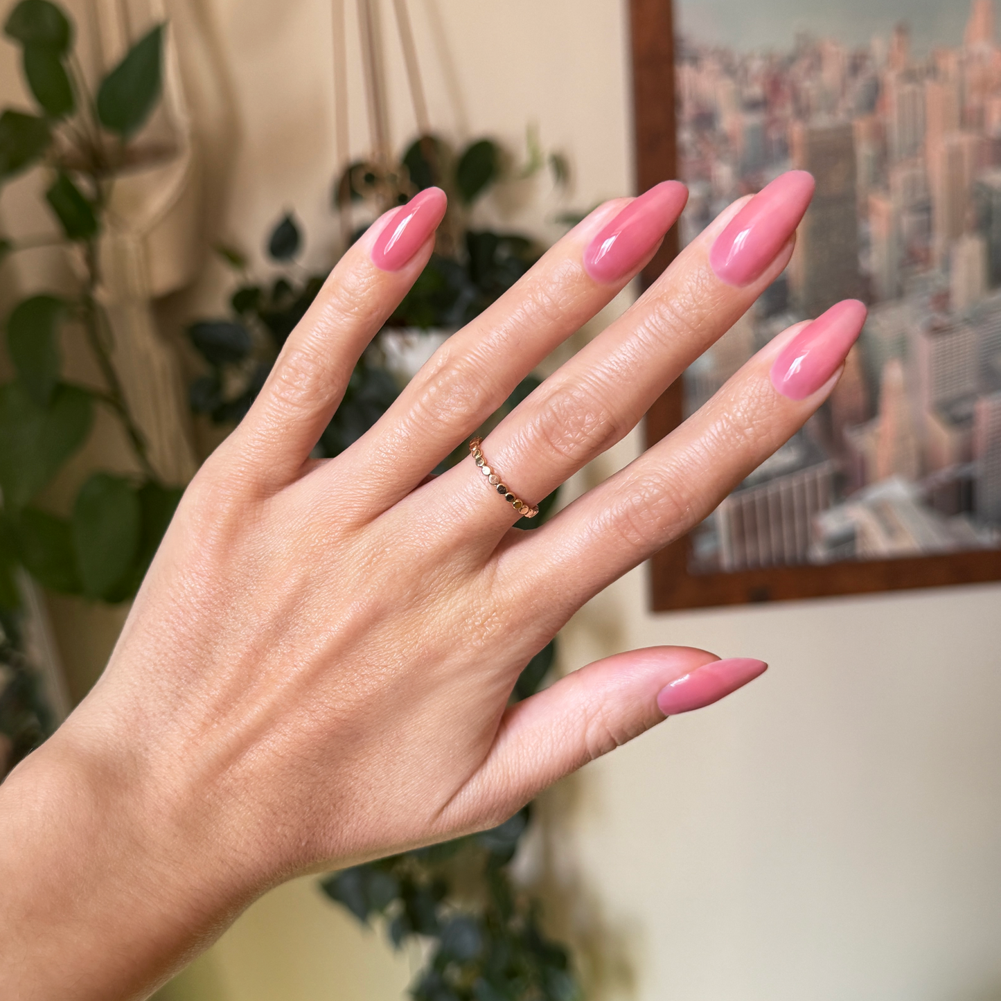 Blush Jelly - Builder Gel on long nails with smooth glossy medium rosy pink manicure in indoor setting with plants background