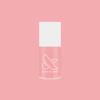 Bottle of Saltwater Taffy sheer pink gel polish by Olive and June displayed against pink background