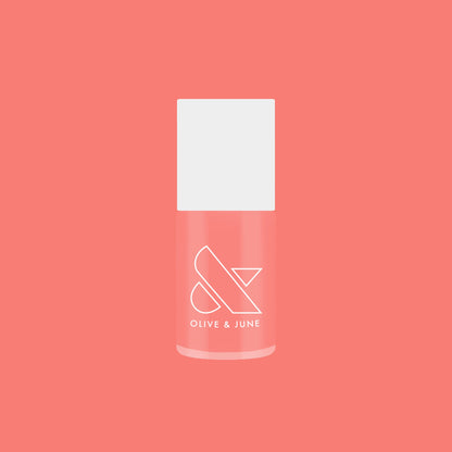 Olive and June Papaya Gloss sheer coral pink nail polish bottle against matching coral background for mani or pedicure