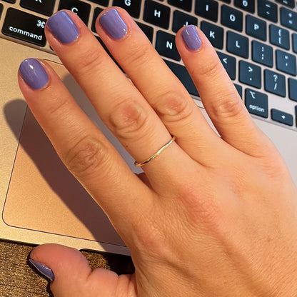 Hand with Royal polish in glossy muted purple on natural nails resting on a laptop keyboard surface