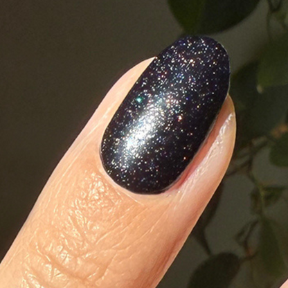 The Celestial Effect Top Coat creating a sparkling micro-shimmer finish on a dark polished nail for a starry manicure