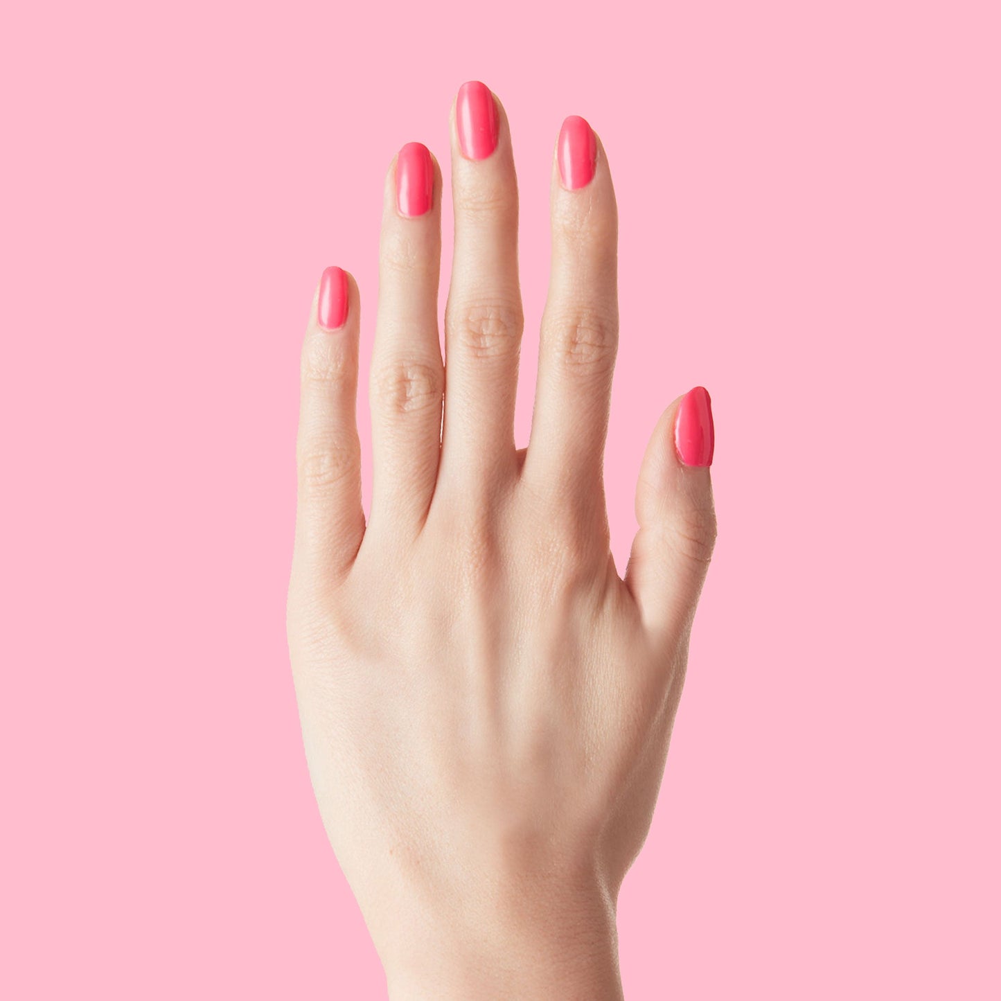 Hand with nails painted in vivid Hot Strawberry gel polish showing bright pink tone against a matching background