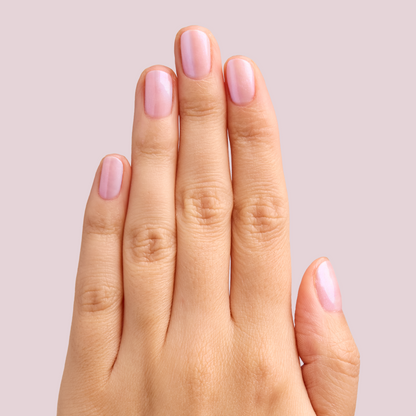 Hand with nails polished in soft pearly pink using BAROQUE Gel for a shiny at-home manicure look