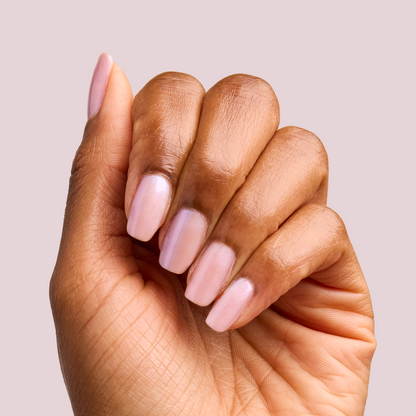 Hand with nails painted in soft pearly pink using BAROQUE Gel for a delicate at-home manicure look