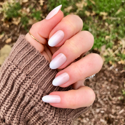 Pure White Syrup Gradient - Press-On | Medium | Oval showing hand with medium oval bright white gradient press-on manicure outdoors