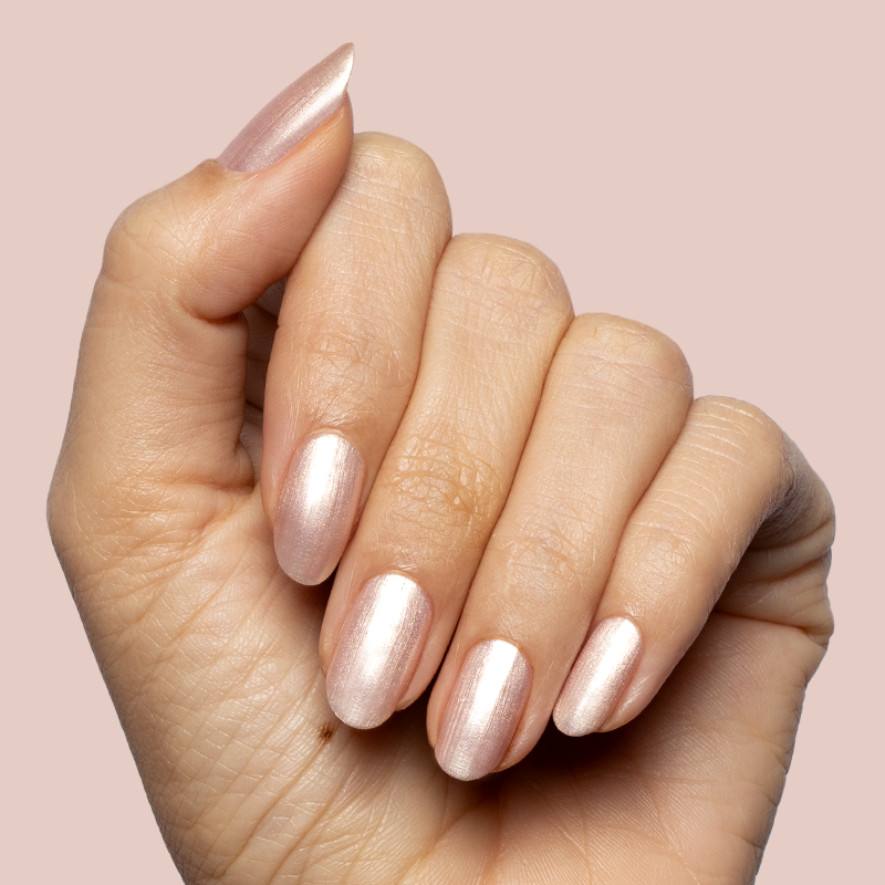 Hand with softly rounded nails painted in sheer shimmering pink Supernova quick dry polish manicure