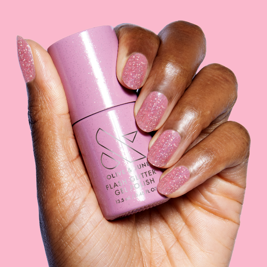 Hand holding Rosé Rhymes with Partay Gel bottle with sparkly cool-toned pink flash glitter gel polish manicure