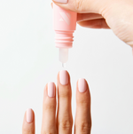 Drop from Dry Drops bottle about freshly manicured nails with soft pink polish for quick drying polish care