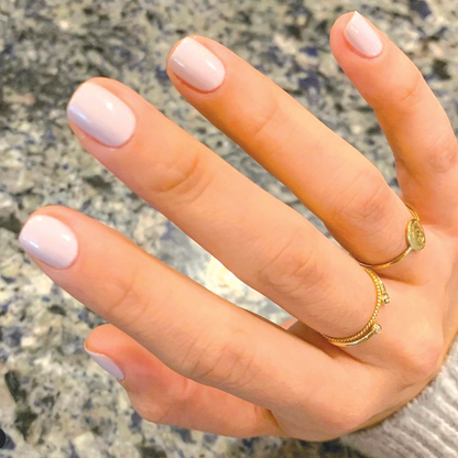 Hand with nails painted in TT gel polish, an almost-pastel lavender shade with balanced grey undertones for an at-home mani